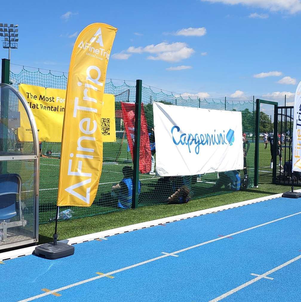 AFineTrip banner beside a sports pitch