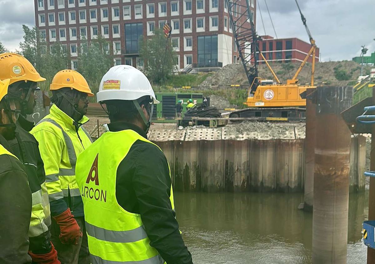 Arcon crew in hi-vis vests on a riverside site