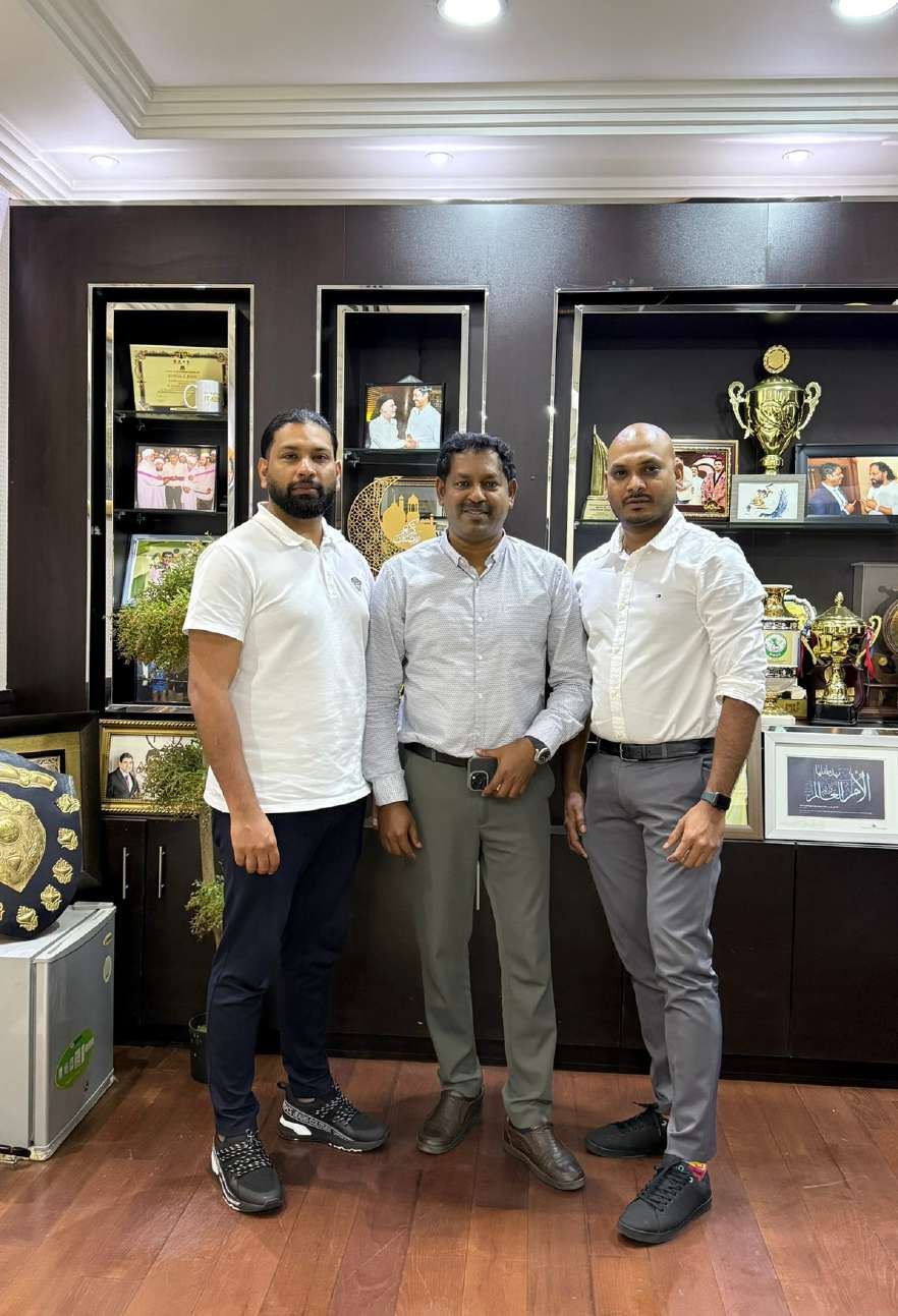 Muneer Shaikh with partners in an office with trophies